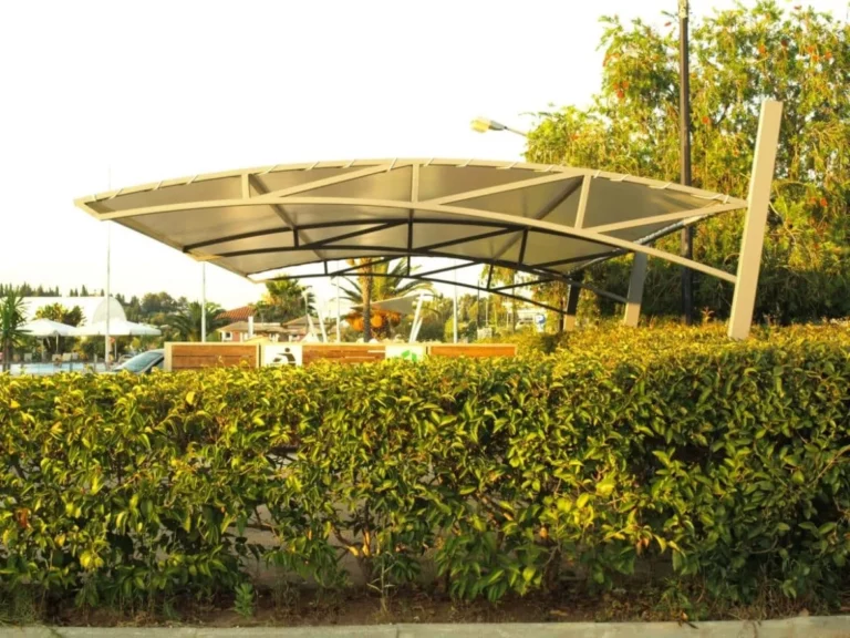 Πλάγια όψη σκίαστρου σε πάρκινγκ αυτοκινήτων με μεταλλικό σκελετό και μουσαμά σκίασης